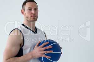 Basketball player holding ball against white background
