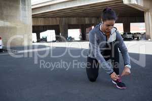Female jogger tying her shoe laces