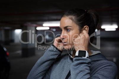 Fit woman listening to music in underground parking area