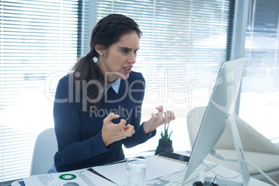 Aggressive female executive looking at desktop pc