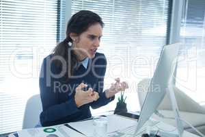 Aggressive female executive looking at desktop pc