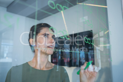 Female executive writing on glass