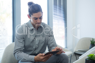 Male executive using digital tablet in waiting area