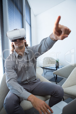 Male executive using laptop and virtual reality headset in waiting room