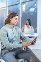 Male executive using digital tablet at desk