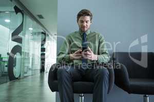 Male executive using mobile phone in waiting area