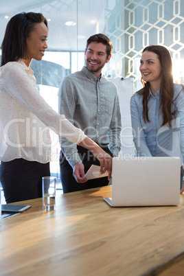 Business colleagues using laptop in conference room