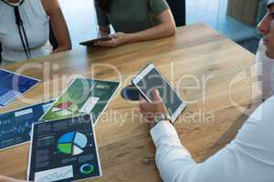 Executive using tablet with business graph on table