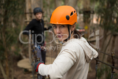 Portrait of hiker woman holding zip line in forest