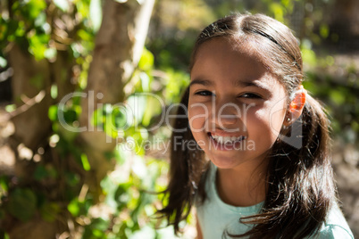 Portrait of happy little girl in the forest on a sunny day