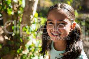 Portrait of happy little girl in the forest on a sunny day