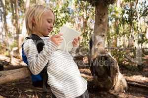 Little girl with a backpack using a tablet