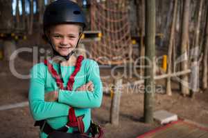 Little girl folding her hands wearing helmet and harness in the forest