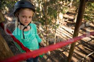 Little girl wearing helmet standing in the forest
