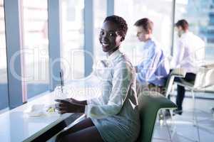 Portrait of smiling female executive having snacks