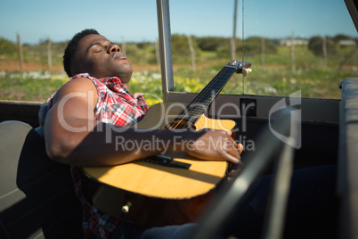 Man playing guitar in car