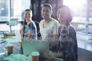 Smiling executives working together at desk