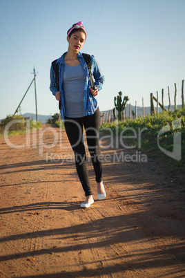 Woman walking on dirt track in countryside