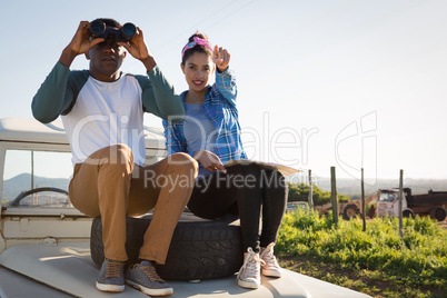 Man looking through binoculars at countryside