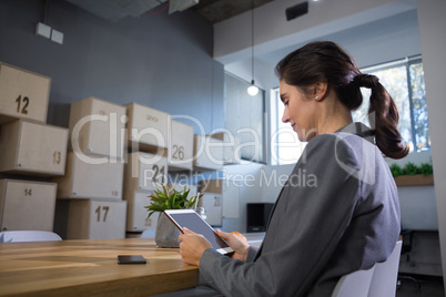 Female executive using digital tablet at desk