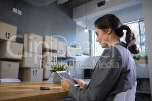 Female executive using digital tablet at desk