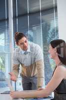 Business executives discussing over laptop at desk