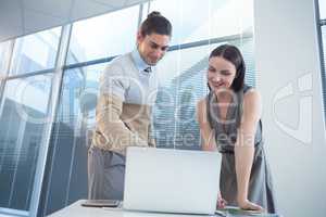 Business executives discussing over laptop at desk