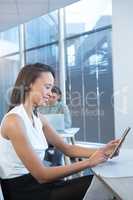 Female executive using digital tablet at desk