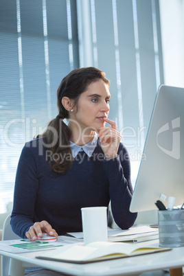 Thoughtful female executive working on computer