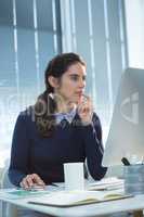 Thoughtful female executive working on computer