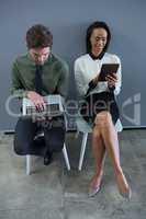 Male and female executives using laptop and digital tabletraftsman polishing fish sculpture 4k
