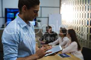 Male executive using digital tablet in conference room