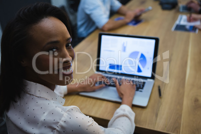 Female executive using laptop in conference room