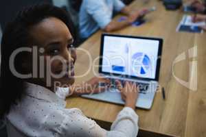 Female executive using laptop in conference room