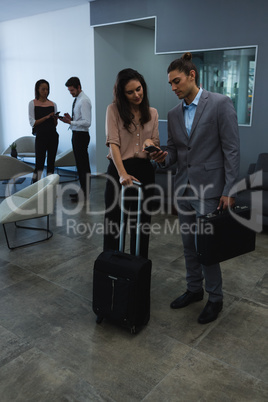 Businessman discussing with his coworker over mobile phone