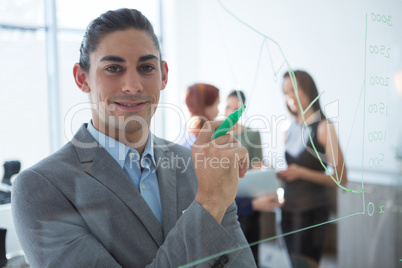 Confident male executive holding marker and looking at camera
