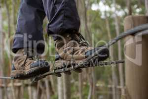 Hiker foot walking on zip line cable in the forest