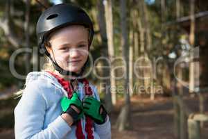 Portrait of little girl wearing helmet, harness and hand gloves