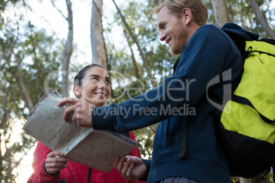 Woman and man hiker with backpack reading map