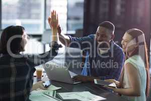 Happy executives giving high five to each other