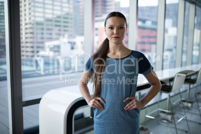 Portrait of female executive standing with hands on hip