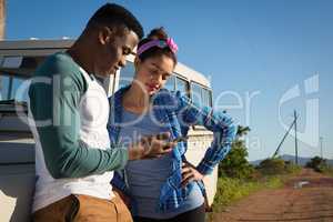 Couple using mobile phone at countryside