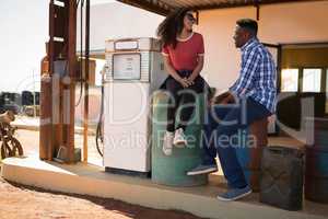 Couple interacting with each other at petrol pump station