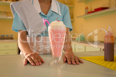 Waitress with ice cream on table in restaurant