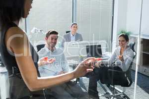 Female executive with his colleagues discussing over glass board