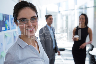 Beautiful female executive wearing spectacles looking at camera