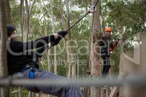 Happy couple crossing through a zip line