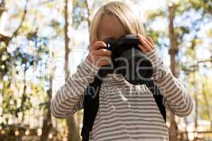 Little girl with a backpack holding dslr camera