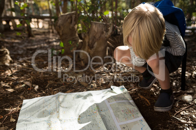 Little girl with backpack reading map