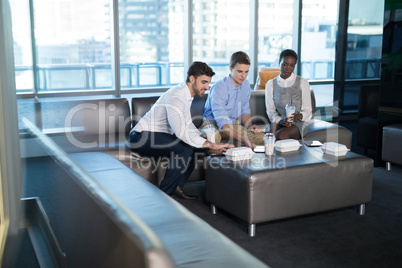 Male and female executives having snacks